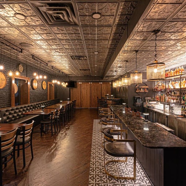 The Barrel Room at Beckett’s, a dimly lit American restaurant with a long bar and dining area.